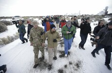 Armed militia refuse to leave government property after men they were "defending" hand themselves in