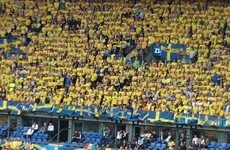 There's an Irish fan dressed as a leprechaun in the middle of the Swedish crowd