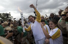 Riot police disperse protesters with tear gas as Olympic torch-bearer moons crowd in Rio