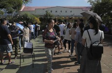 Hong Kong voters wait in hundred metre-long queues to cast their ballot in elections