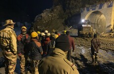 Indian rescuers begin drilling debris-filled tunnel in bid to reach dozens of people trapped inside