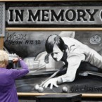 File photo dated 01/08/10 of a woman taking a picture of a new mural of Alex Higgins at the Royal Bar on Belfast's Donegal Road where his funeral cortege will pass along on it's way to St Anne's Church of Ireland Cathedral where the funeral service will be held.