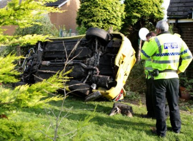 Police study the Mitsubishi Lancer Evolution written-off by their colleagues.