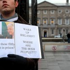 A campaigner stands outside Leinster House this morning, as news breaks of a Green Party press conference on the future of the government. Julien Behal/PA Wire