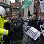 A motorbike police officer holds back Sinn Fein protesters - including party TD Aengus Ó Snodaigh - who broke through the gates at government buildings. (AP Photo/Peter Morrison)