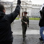A Irish Army Military police officer confronts Sinn Fein protesters after they broke through the gates at government buildings. (AP Photo/Peter Morrison)