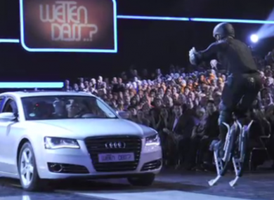 Samuel Koch (23) attempts to jump over a grey Audi driven by his father. Seconds later, he struck his head off it, knocking him unconscious on live television watched by millions.