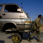 A Pakistani worker transports the front portion of a van on his hand-cart at a road in Rawalpindi, Pakistan on Tuesday.