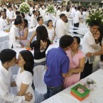Newly-wed Filipino couples kiss during ceremonies at a mass wedding in the suburban city of Taguig, south of Manila. About 140 couples joined the mass wedding sponsored by local government officials. (AP Photo/Aaron Favila)