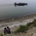 An Indian couple share a moment as a boat passes by on the river Brahamaputra, Gauhati, India. (AP Photo/Altaf Qadri)