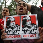 A Libyan living in Malaysia holds a picture of Libyan leader Muammar Gaddafi outside the Libyan Embassy in Kuala Lumpur. Pic: AP Photo/Lai Seng Sin.