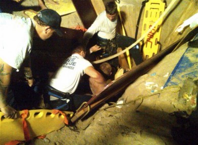 Maly is pulled from his sandy tomb by rescuers in Florida