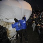 Security staff and members of direct action group Art Uncut, tussle over a 20ft balloon emblazoned with the message 