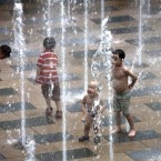 Children plays at a water fountain in Sanlitun Village during summer day in Beijing, China, on 17 July, 2011. (AP Photo/Andy Wong)