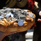 A relative of the bridegroom gives a cake and jewellery as a present for the bride, during the traditional Galicnik Wedding on 17 July, 2011, in Macedonia's western village of Galicnik. Traditional Galicnik Wedding is held every year on the first weekend after the Orthodox St. Peter's day. (AP Photo/Boris Grdanoski)