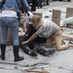 A victim is treated outside government buildings in the centre of Oslo on 22 July, following an explosion that tore open several buildings including the prime minister's office, shattering windows and covering the street with documents. (AP Photo/Fartein Rudjord)