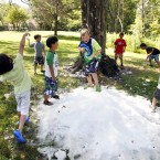 Enjoying a snowball fight with ice shavings delivered from an indoor ice-hockey arena in Andover, Massachusetts. (AP Photo/Elise Amendola)