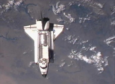 The space shuttle flies over the Earth in an image taken from the International Space Station