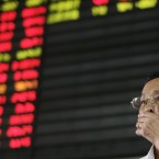 An investor covers his mouth as he looks at the stock price monitor in Shanghai, China (AP Photo)