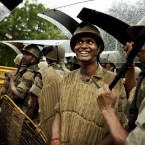 Police officers use riot shields to shelter themselves during a rain shower at a protest in New Delhi, India (AP Photo/Kevin Frayer)