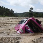 A passenger bus lies half buried in rubble after heavy rainfall on the outskirts of Jammu, India (AP Photo/Channi Anand)