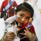 Abbey Chan from Malaysia holds the dolls (AP Photo/Alastair Grant)