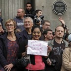 Fans, one carrying a placard with a message, wait for the couple (AP Photo/Lefteris Pitarakis)