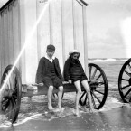 Young girl and boy sitting on a bathing box in shallow water (1890-1910). Courtesy of the National Library of Ireland.