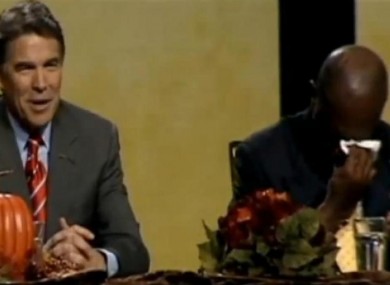 Rick Perry speaks as Herman Cain wipes away his tears.