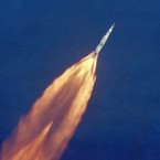 Rockets propel Apollo 11 away from the Earth's surface. This image was captured by a telescopic camera mounted on an Air Force plane. (NASA)