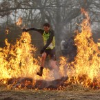 A competitor runs through flames at the annual Tough Guy event. (AP Photo/Jon Super/PA Images)