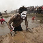 A competitor crosses one of the obstacles on the gruelling Tough Guy course. (AP Photo/Jon Super/PA Images)