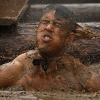 Emerging from a very muddy water obstacle. (AP Photo/Jon Super/PA Images)