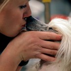 Owner and handler Anna Carlsson, of Sweden, kisses her Chinese Crested dog Prefix. (AP Photo/Craig Ruttle/PA Images)