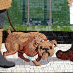 Detail of a mosaic of a dog being walked on the station platform (Via mural-to-mosaic.blogspot.com)