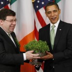 On his first St Patrick's Day in office, President Barack Obama receives shamrock from Taoiseach Brian Cowen at the White House. (AP Photo/Gerald Herbert/PA Images)