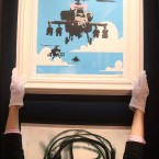A Bonham's employee adjusts Banksy's Happy Choppers, estimated to fetch £4,000 - £6,000 at Urban Art auction. (Lewis Whyld/PA Images)