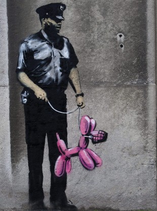Graffiti from famed British graffiti artist Banksy is displayed on a wall in Toronto. 