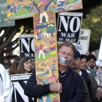 Actor Martin Sheen carries a cross as he marches in a procession around the Federal Building in Los Angeles during a prayer vigil for peace in 2003. (AP Photo/Nick Ut)<span class=