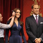 The new wax figures of the Duke and Duchess of Cambridge are given a final comb of the hair by make-up artist Rebecca Holmes before they go on display. (John Stillwell/AP Images)