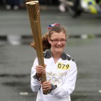 Torchbearer 079 Emily Woodward carries the Olympic Flame on the Torch Relay leg through Warrington, England. (Gareth Fuller/LOCOG/Press Association Images)
