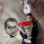 An Egyptian flowers vendor in front of graffiti depicting president Hosni Mubarak, two days before Mubarak is to hear the verdict on charges of corruption and complicity in killing protesters during last year's uprising. (AP Photo/Amr Nabil)