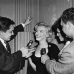 Actress Marilyn Monroe flashes radiant smile behind microphones of newsmen (AP Photo)