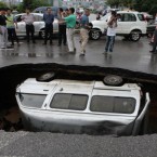 A van is trapped in a hole after a cave-in happened at Fuxing road in Guilin, Guangxi Province. (Photo by He Zhiqin/ChinaFotoPress/PA)