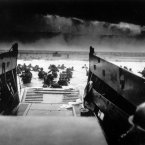 While under attack of heavy machine gun fire from the German coastal defense forces, American soldiers wade ashore off the ramp of a US Coast Guard landing craft on 6 June, 1944. (AP Photo)