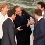 Silvio Berlusconi grasps the arm of Japanese PM Taro Aso and laughs at his cufflinks as world leaders look on helplessly. (Oli Scarff/PA Wire)