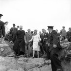 Princess Grace of Monaco uses a black-throne stick and wears flag heeled shoes, as she makes her way under escort of the Rev. Father to Cummins, left, and an unidentified man, during pilgrimage to the shrine of St Patrick at Croagh Patrick, Westport in 1961. (AP Photo)