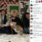 Wearing a furry hat and petting a young tiger.
