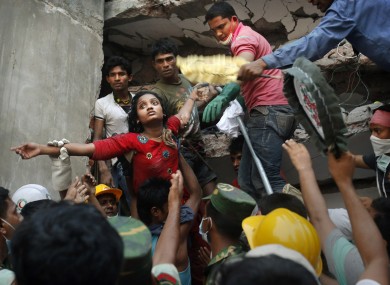 A Bangladeshi woman survivor is lifted out of the rubble by rescuers after the collapse of Rana Plaza. 